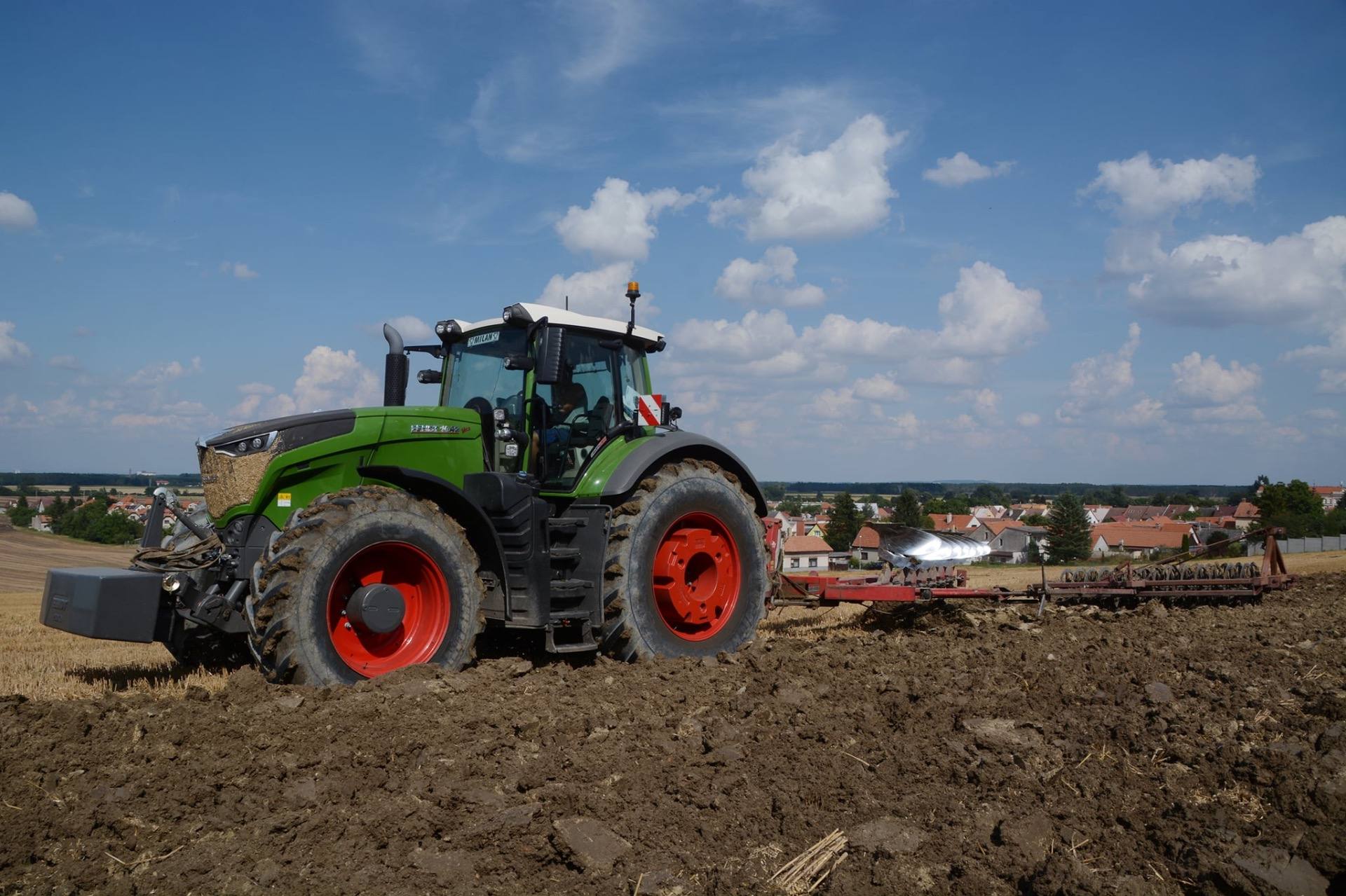 Traktor Fendt zpracovává půdu na poli.